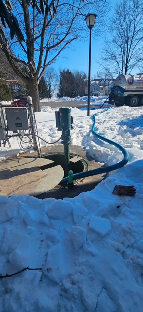 Person pumping out a septic tank in a yard with green grass and foliage. Person pumping out a septic tank in a yard with green grass and foliage.