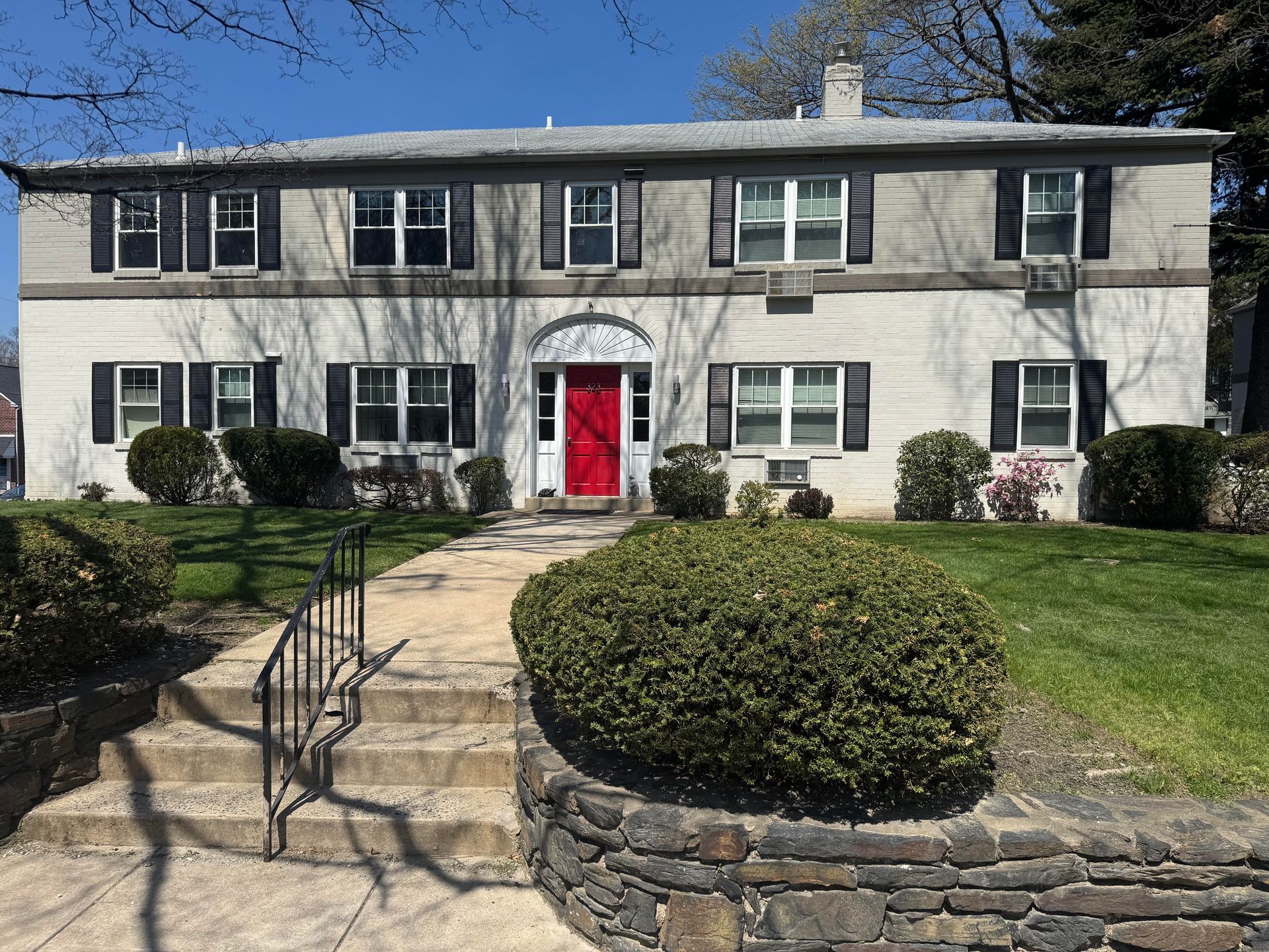 Multi-story apartment building with brown wood accents, blue balconies, against a sunny sky.