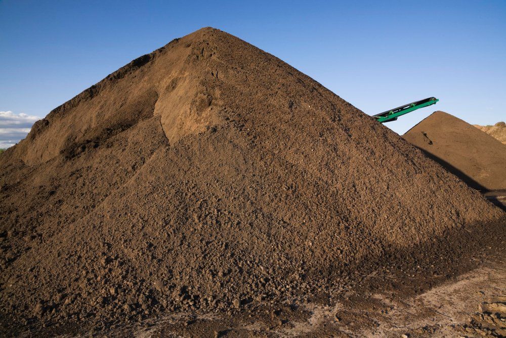 A large pile of dirt is sitting on top of a dirt hill.