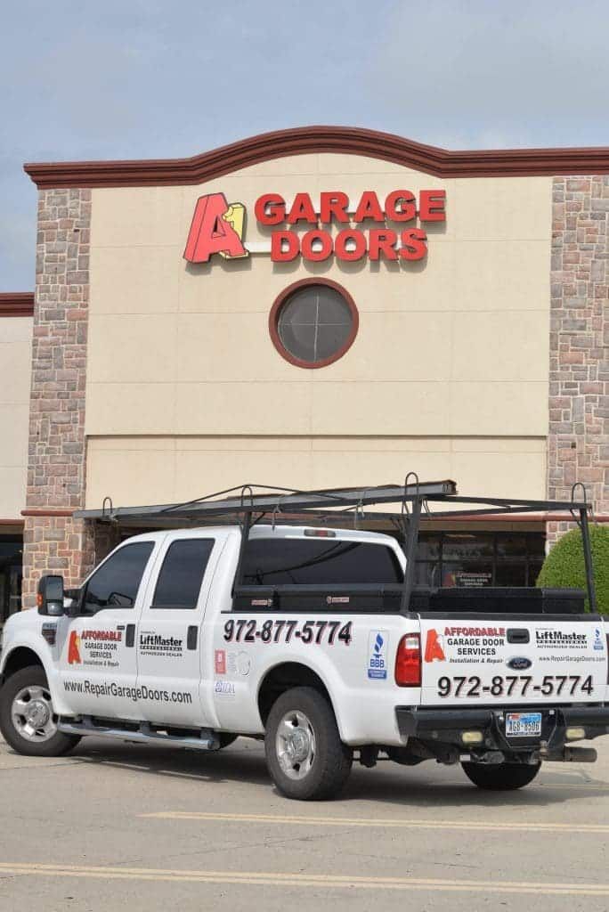 A1 Affordable Garage Door Services sign on office building with service truck in front