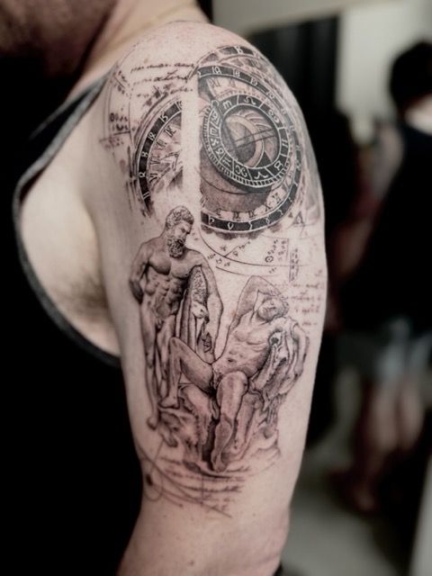 Tattoo on arm depicts classical statues, clock, and sketched background. Black and white, on person's arm.