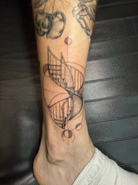 Tattoo of a spiral staircase on a leg, with geometric elements. Light skin tone, black ink.