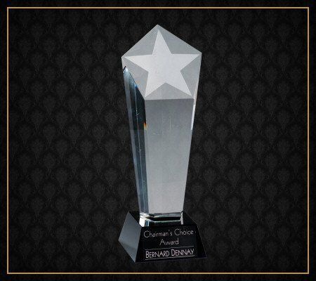 A clear glass trophy with a white star on top