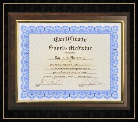 A certificate for sports medicine is framed in a wooden frame