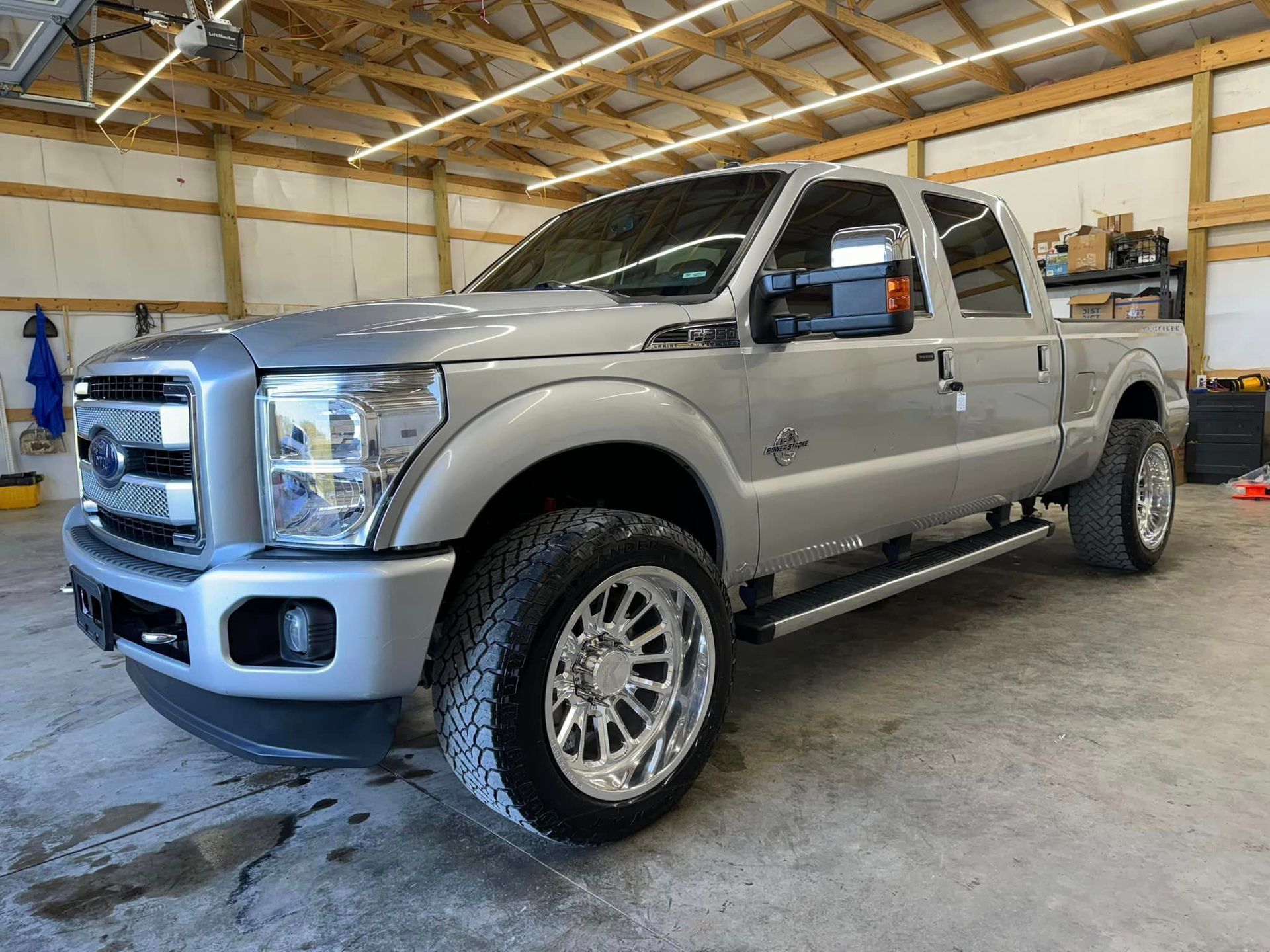 A silver pickup truck is parked in a garage.