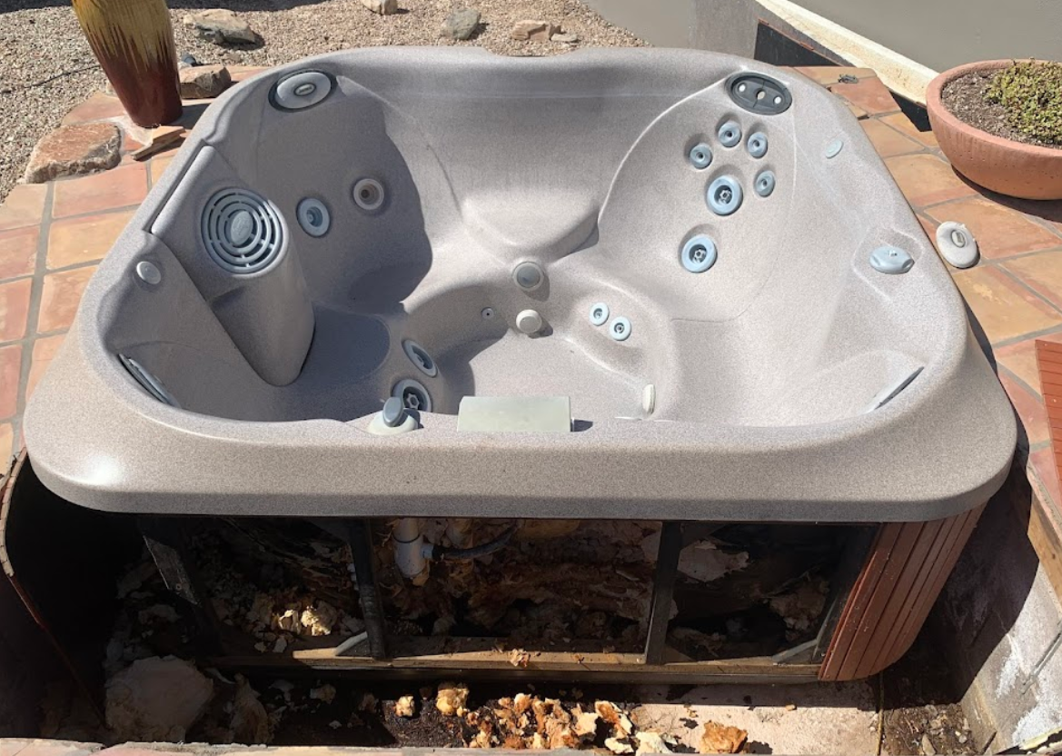 A hot tub is sitting on top of a tiled floor.