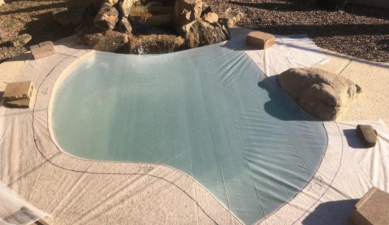 A large swimming pool is covered in a white tarp.