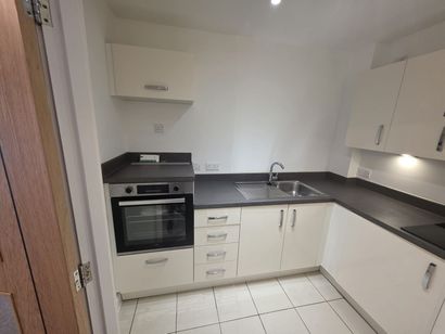 A kitchen with white cabinets and black counter tops