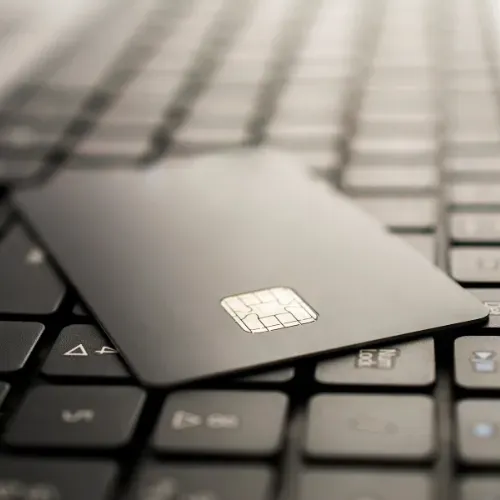 A credit card is sitting on top of a laptop keyboard.