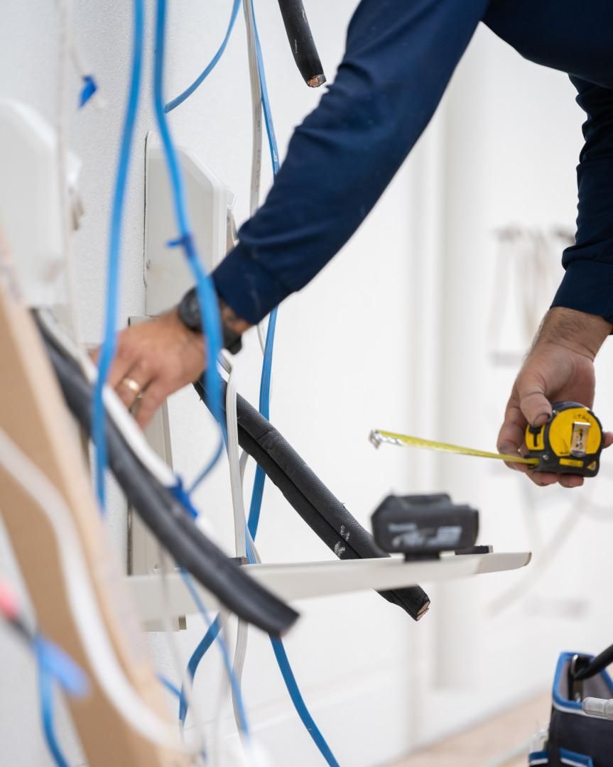 A Man Is Measuring Something with A Tape Measure — Staub Air in Garbutt, QLD