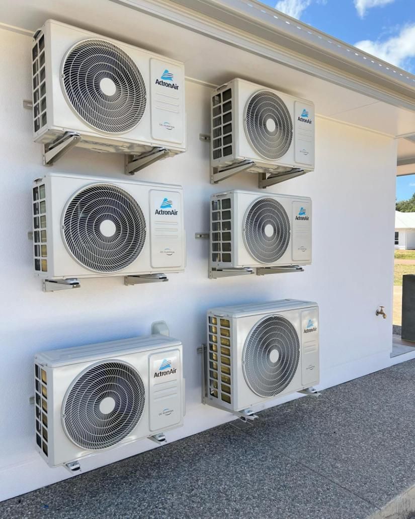 A Row of Air Conditioners Mounted on A White Wall — Staub Air in Garbutt, QLD