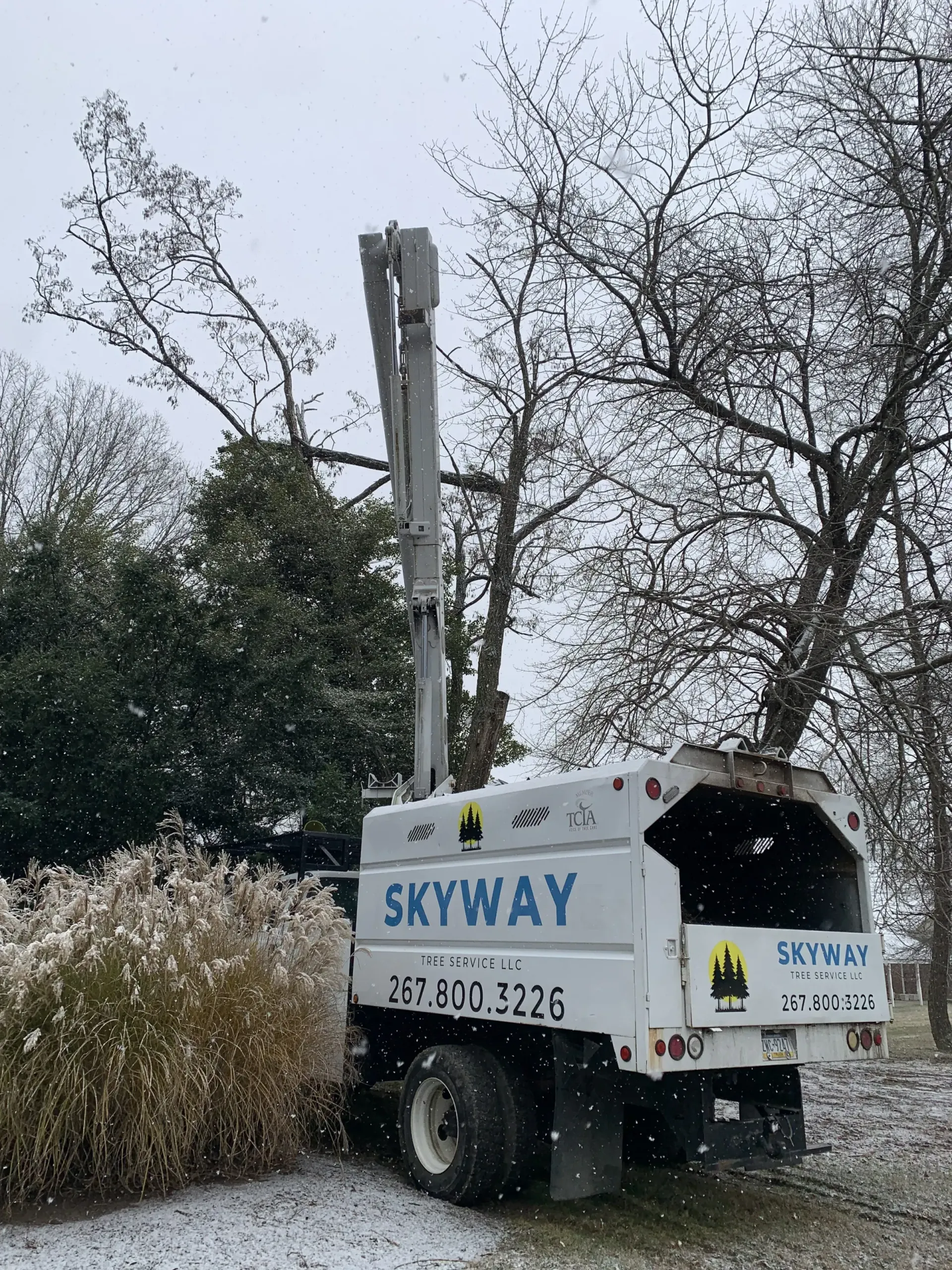 A skyway tree stump grinder is parked in the snow.