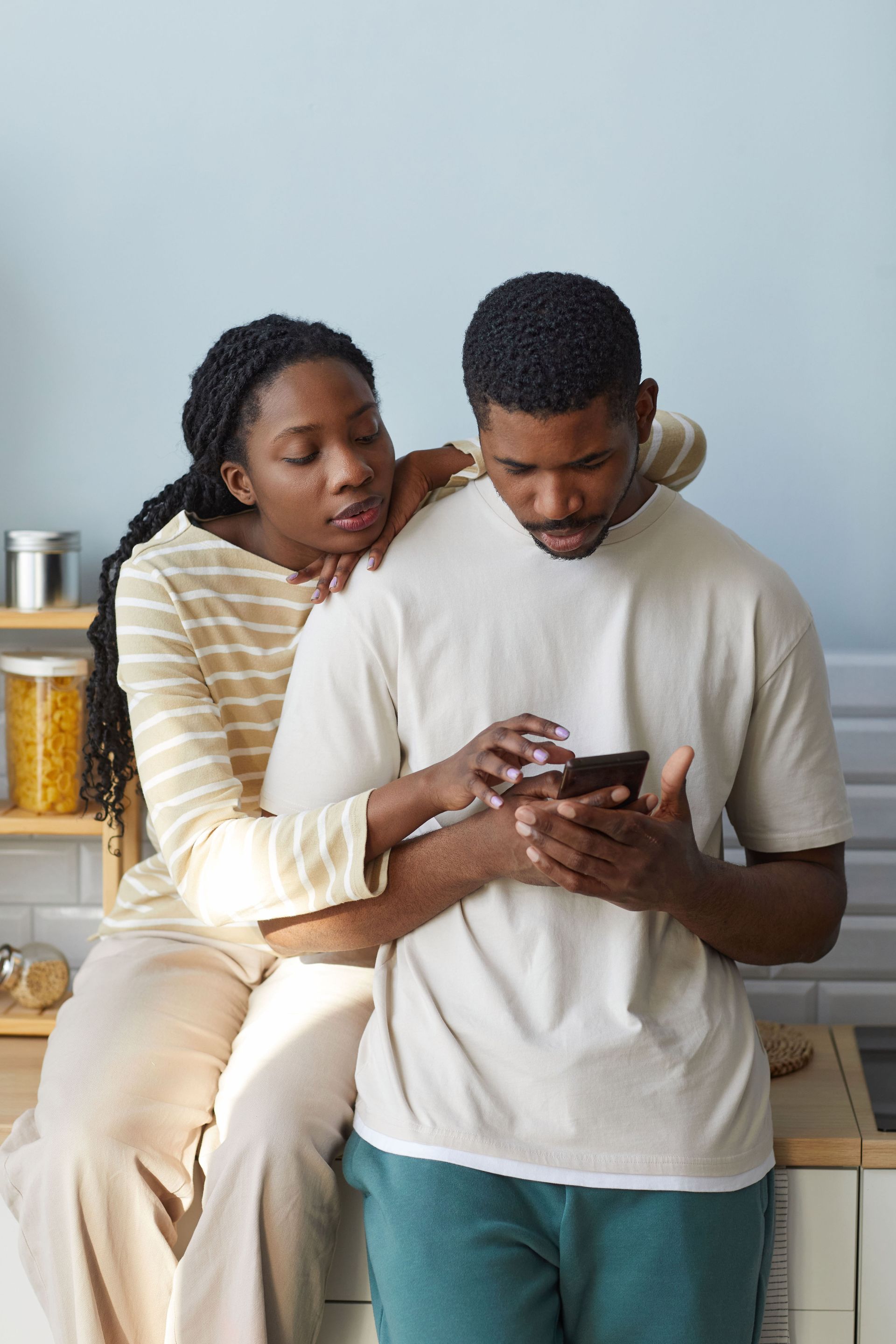 A therapist speaking to a couple on a couch. The therapist is black, the couple is white. Neutral setting.
