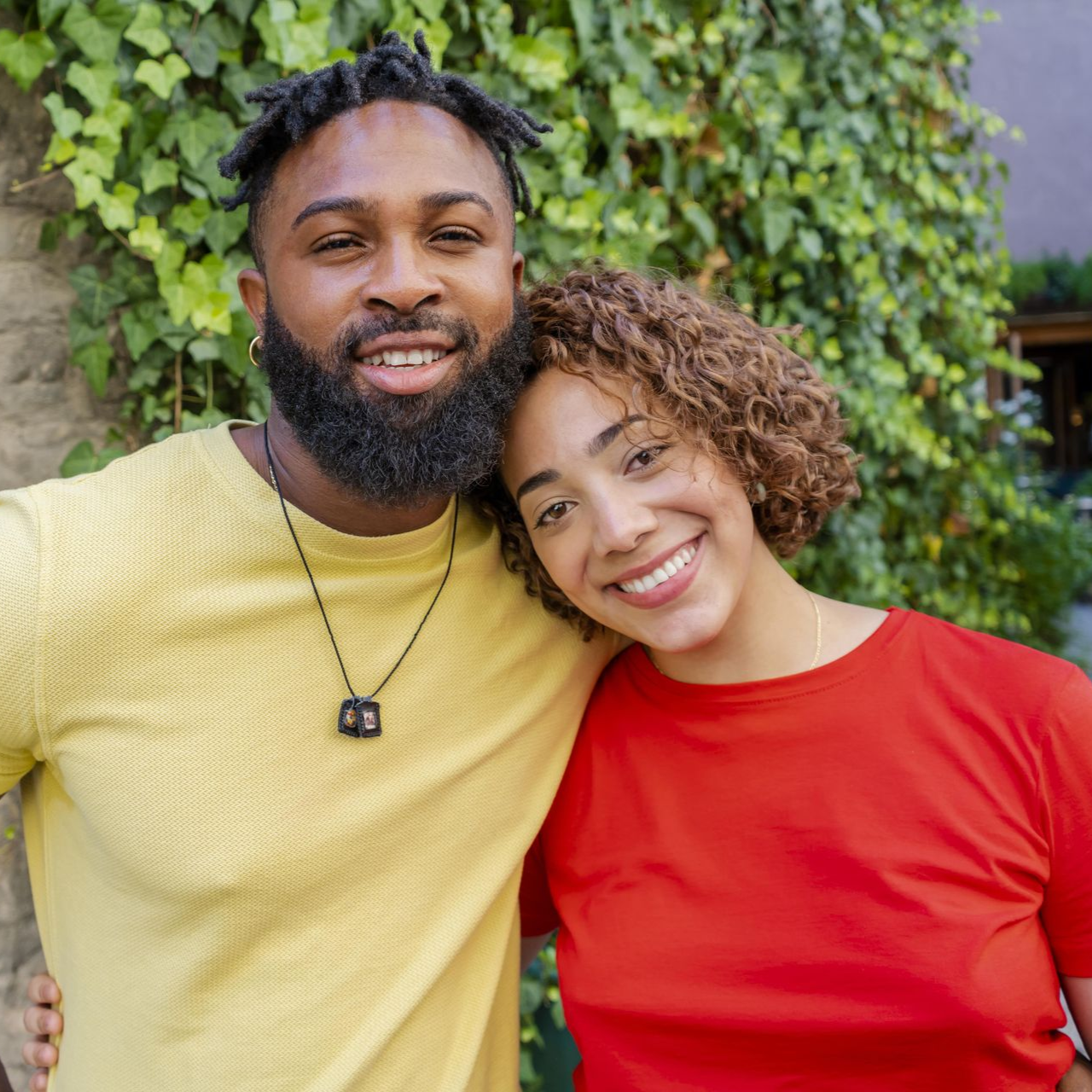 Bride and groom hold each other, woman in white dress holding pink and white roses.
