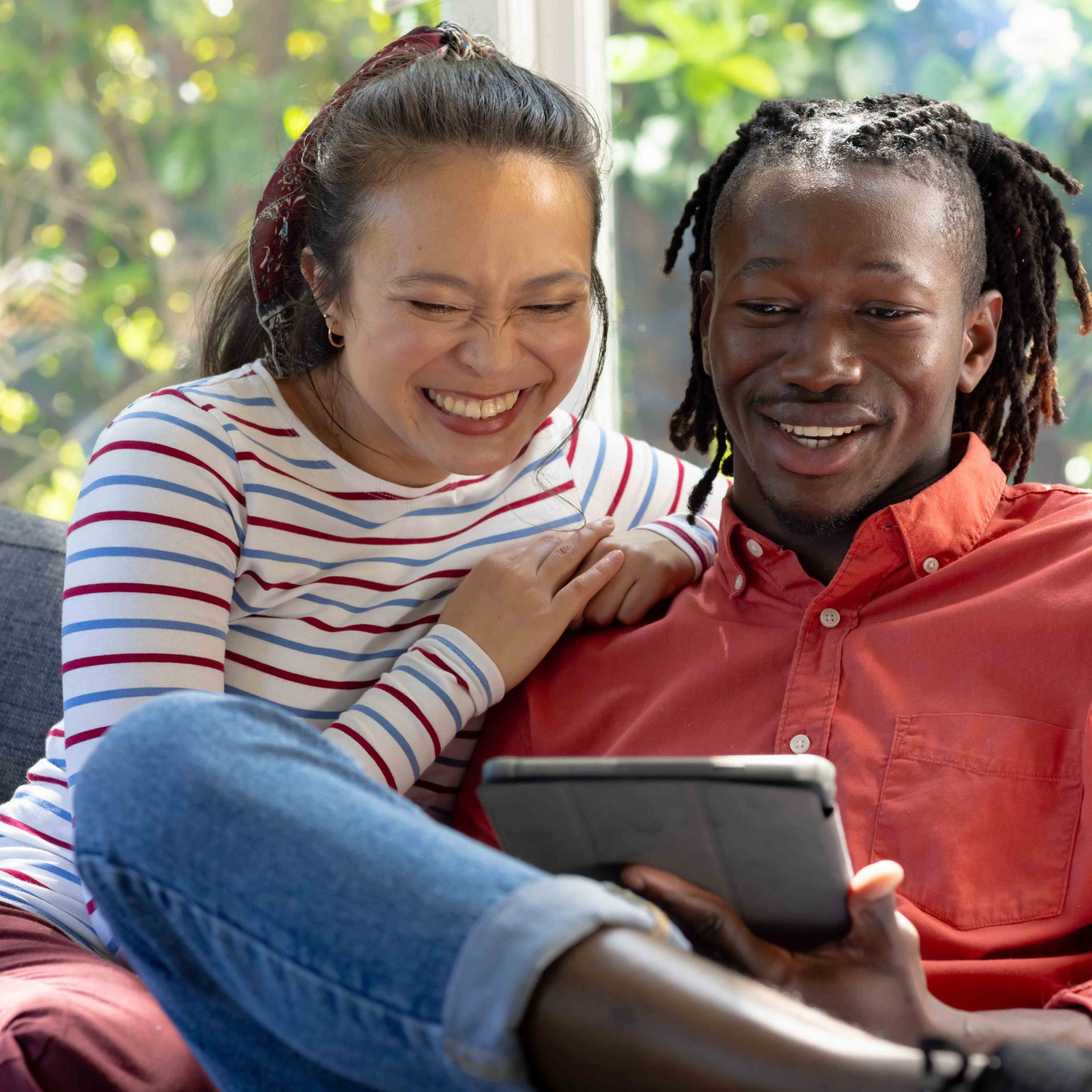 Couple in couple's therapy, arms crossed, looking at therapist. Light-colored room with a white couch.