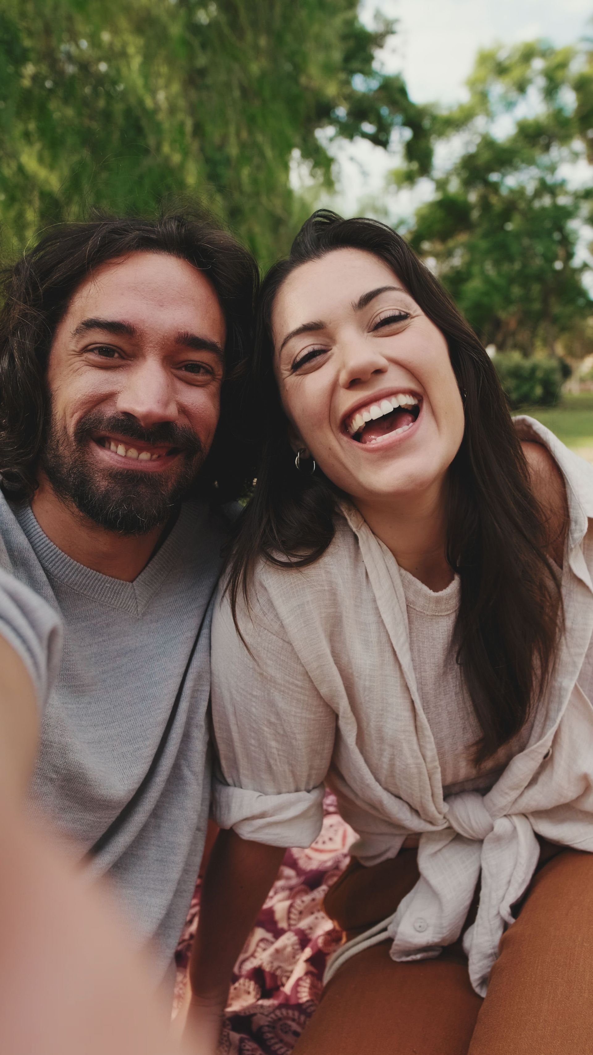 Man at table looks at woman, indoors by window.