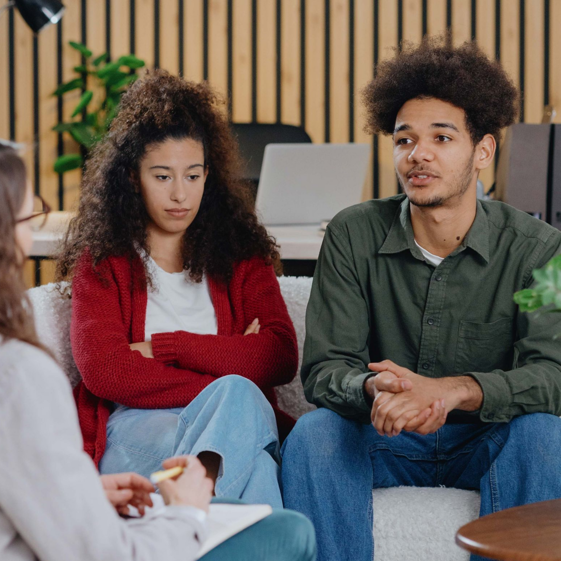 Couple in therapy session talking with counselor.