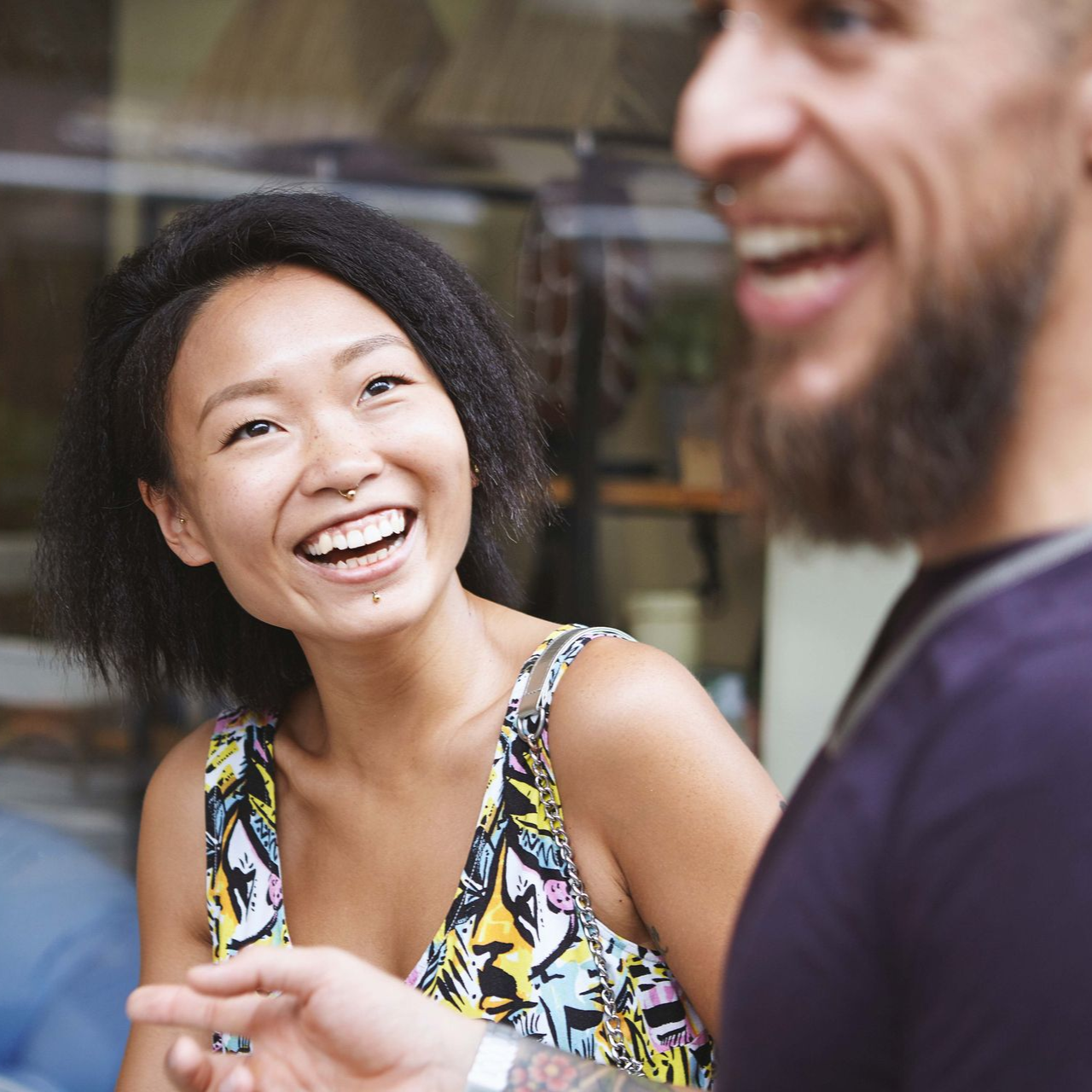 Therapist takes notes while patient sits on a sofa, hands clasped.