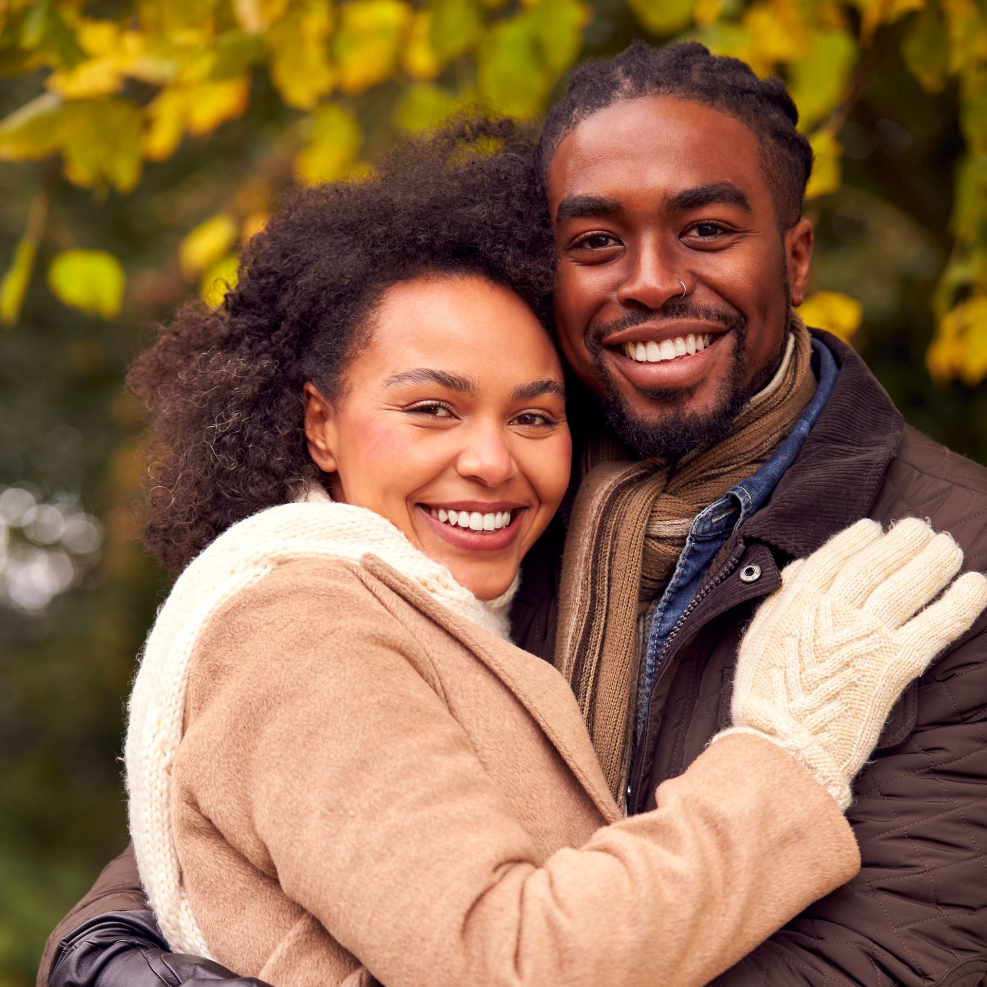 Couple in crowns at altar during Orthodox wedding ceremony.