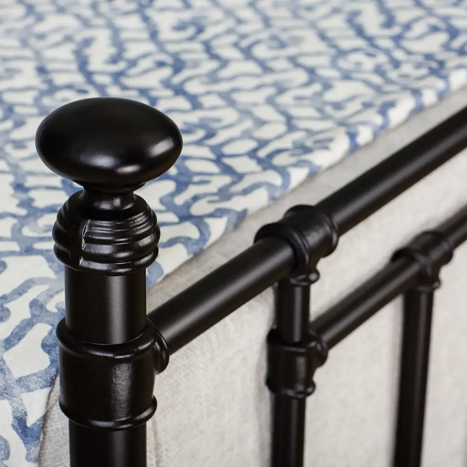 A bed with a blue and white patterned blanket on it
