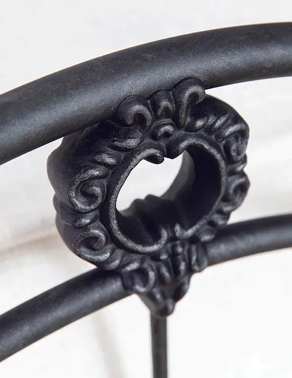 A close up of a black metal railing with a heart on it