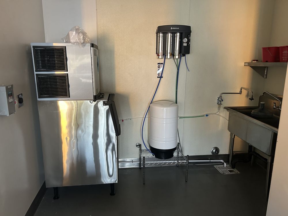 White wall-mounted boiler in a brick-walled room. Yellow gas pipes attached.