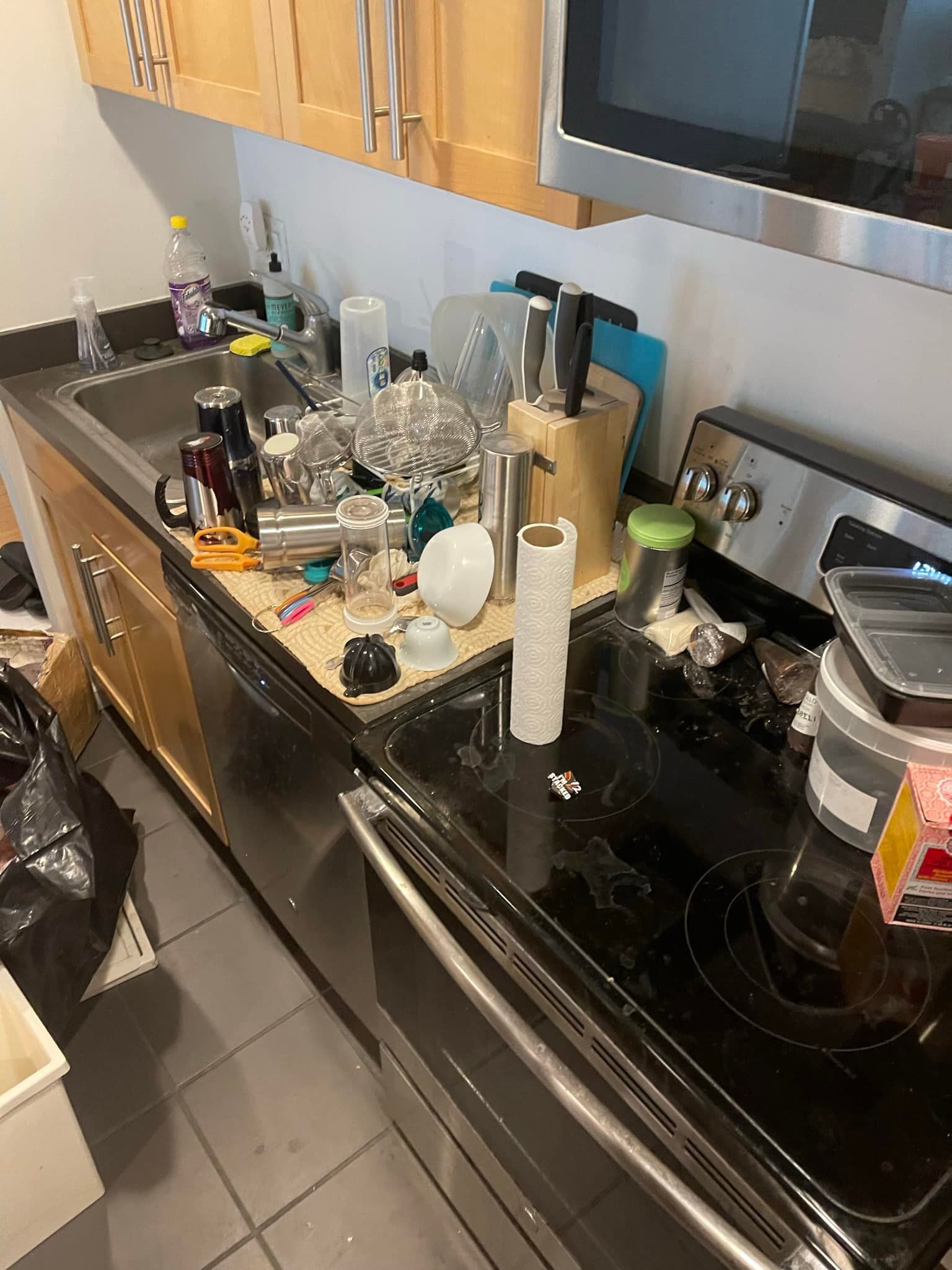 Messy kitchen counter and stove with dirty dishes, utensils, and appliances.