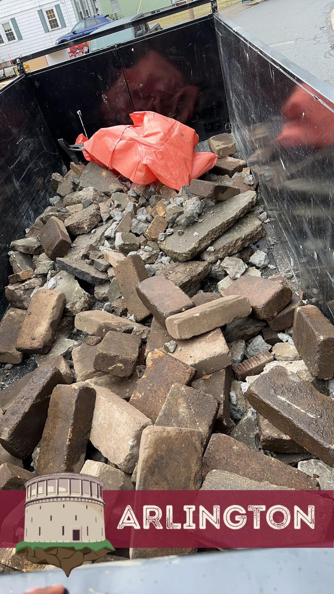 Dumpster filled with broken bricks and an orange tarp; Arlington, VA.