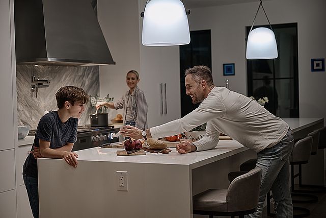 A man and a boy are sitting at a table in a kitchen.