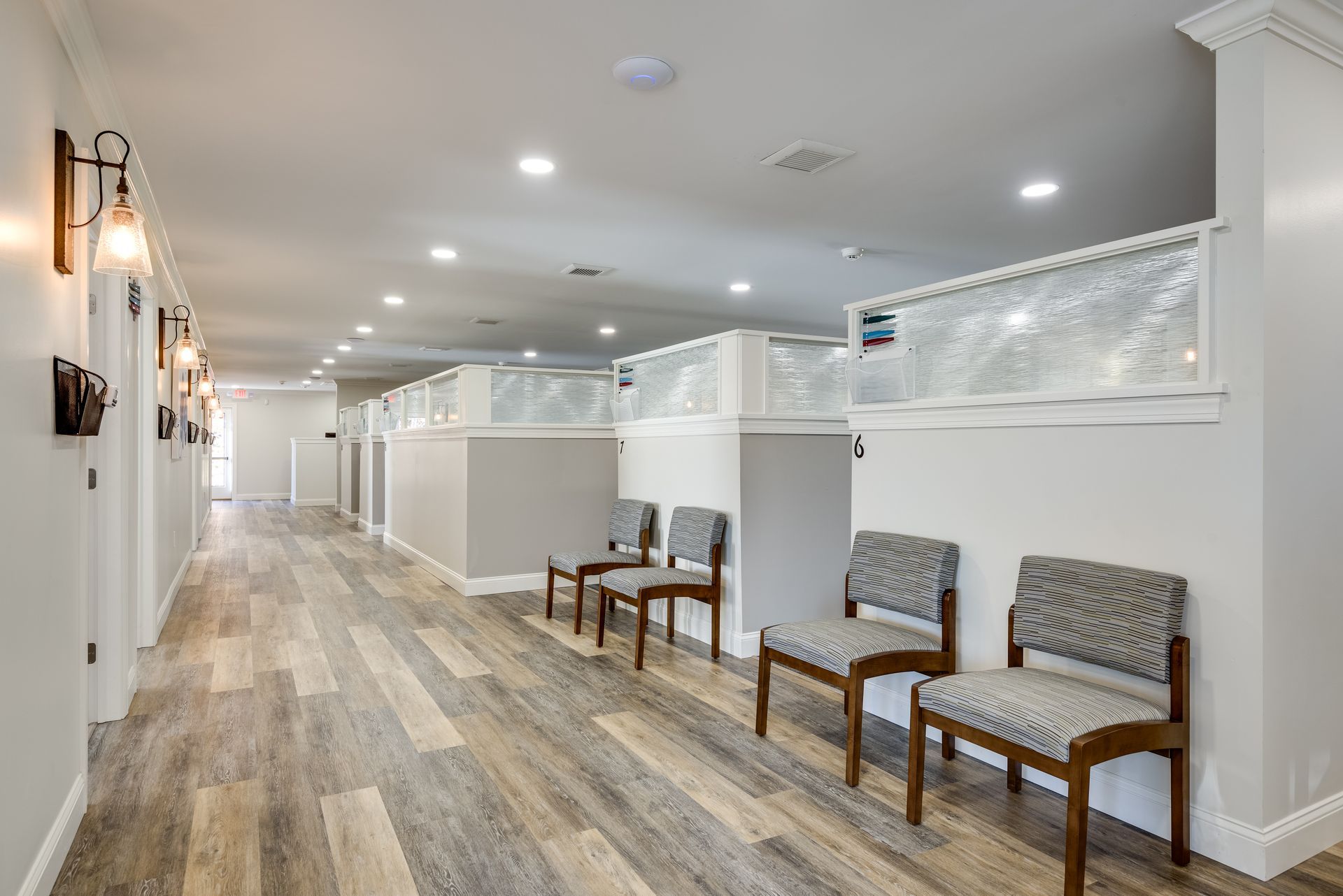 A long hallway with a row of chairs in it.