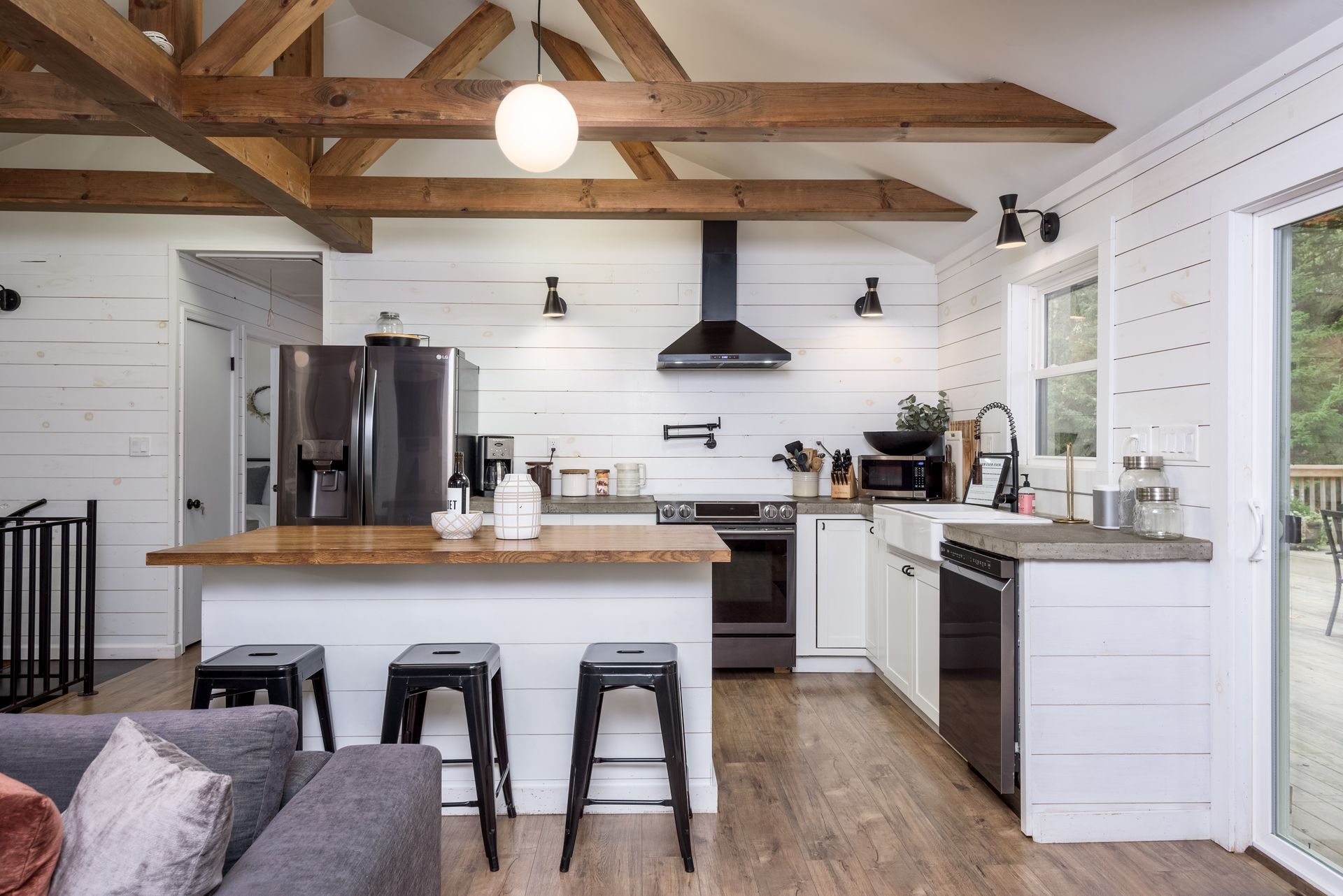 A kitchen with white cabinets , stainless steel appliances and a large island.
