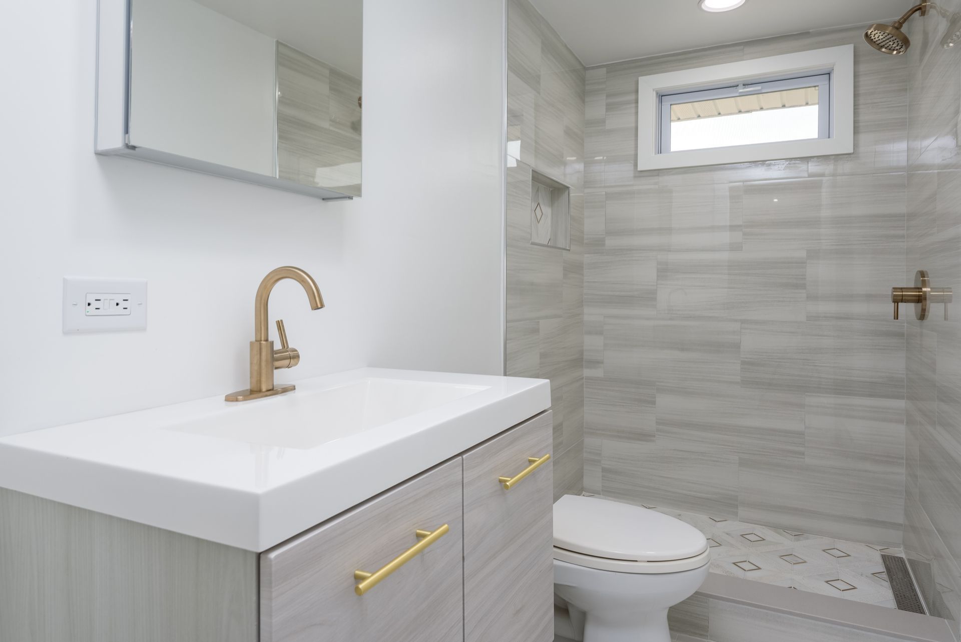 A bathroom with a sink , toilet and shower.