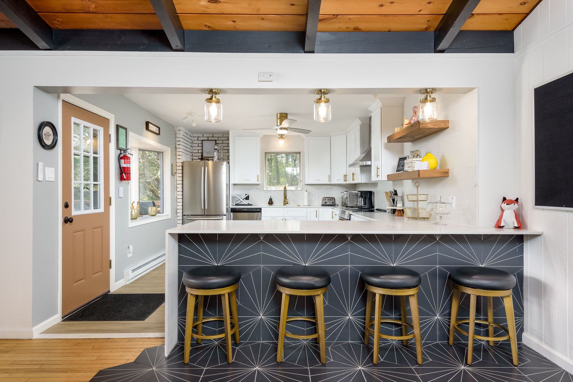 A kitchen with a bar and stools in it