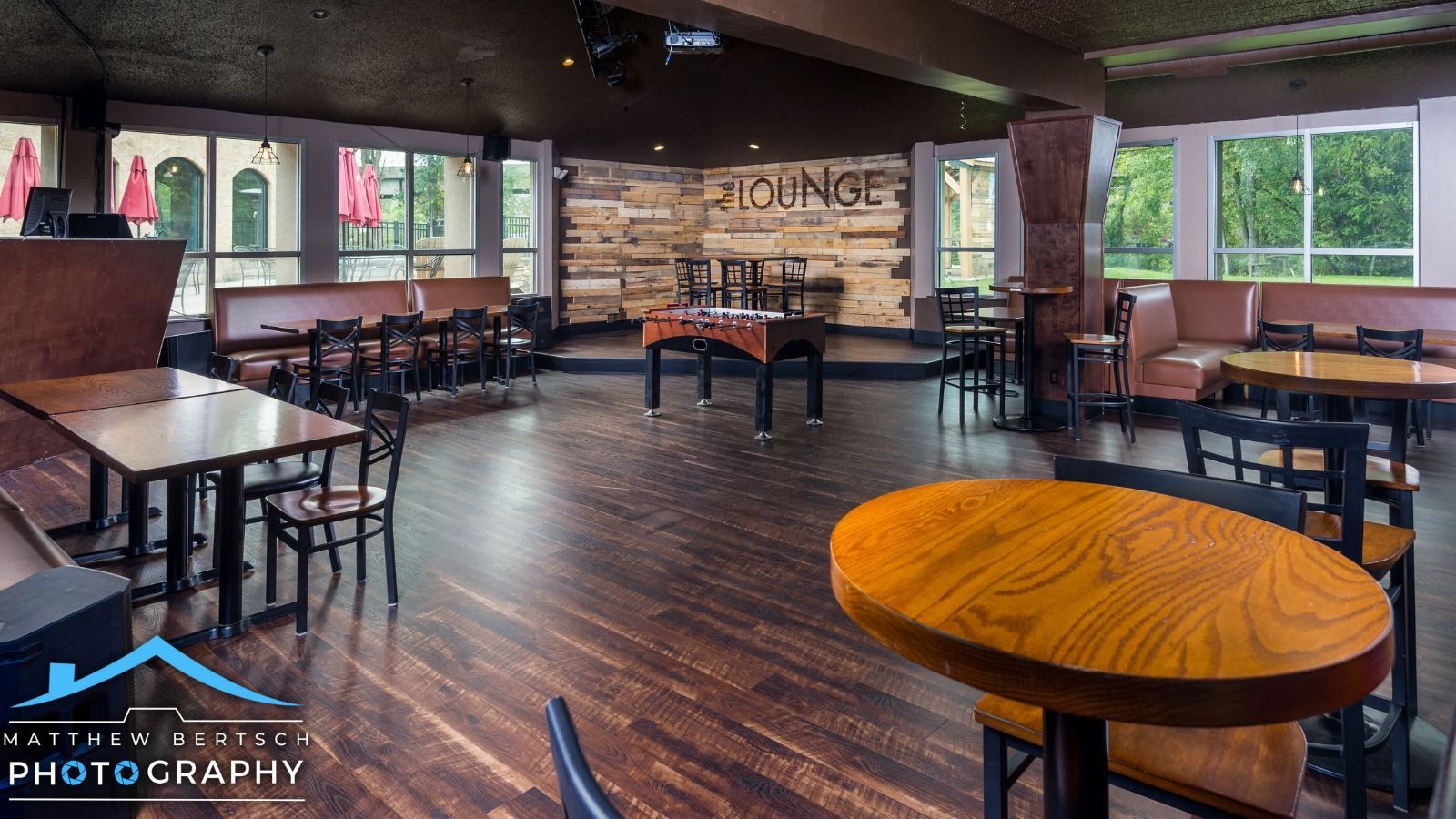 A restaurant with tables and chairs and the word lounge on the wall