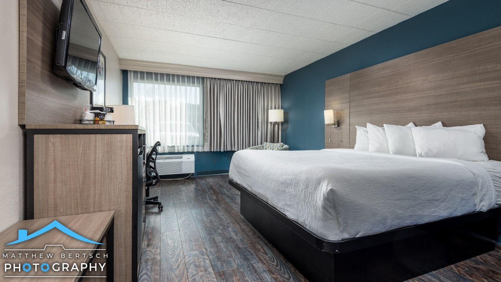 A hotel room with a king size bed and a flat screen tv.