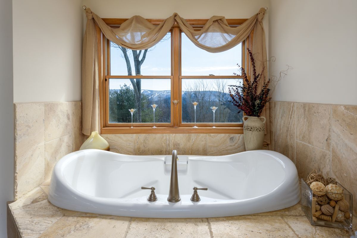 A bathroom with a large tub and a window.