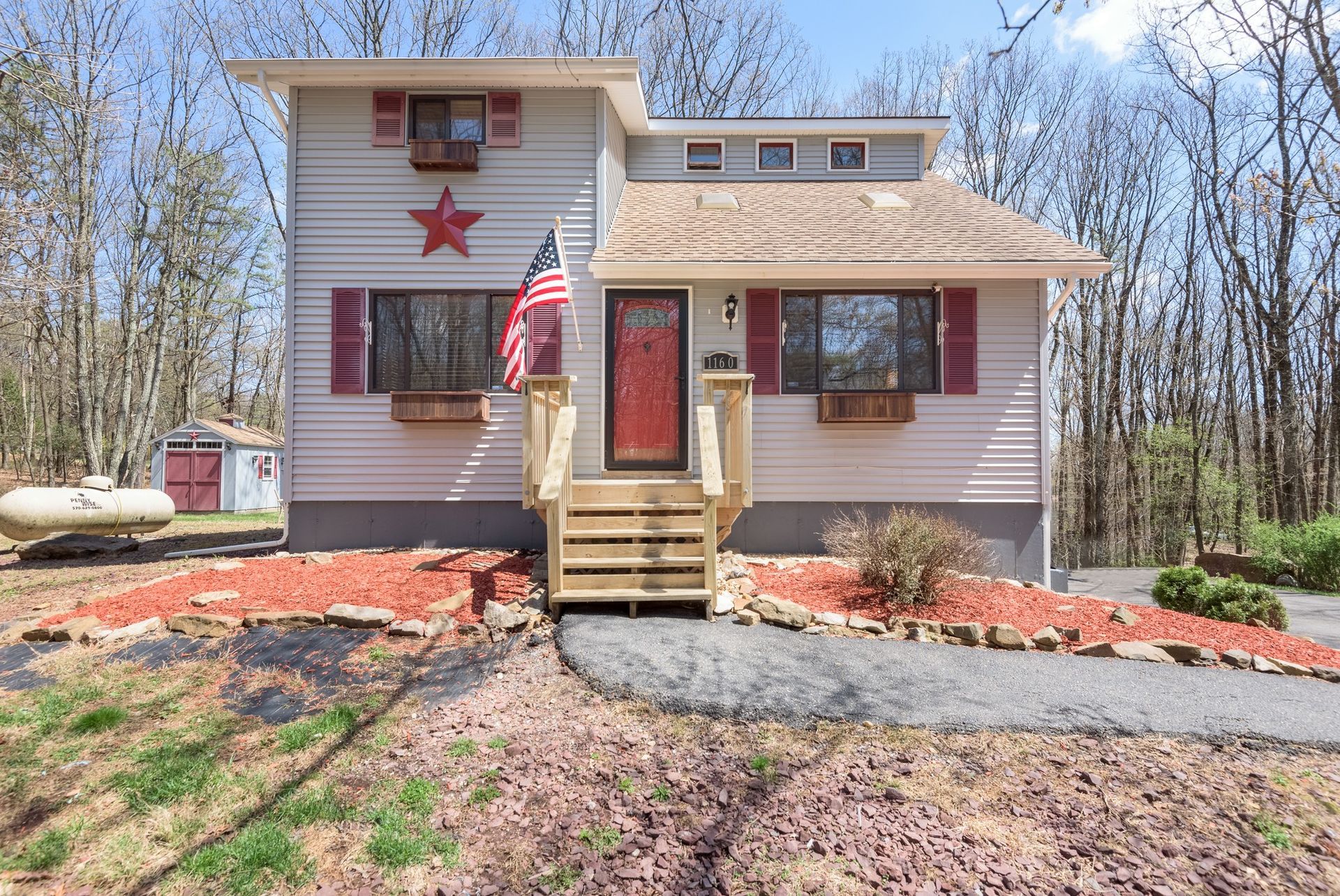 A white house with red shutters and a red door