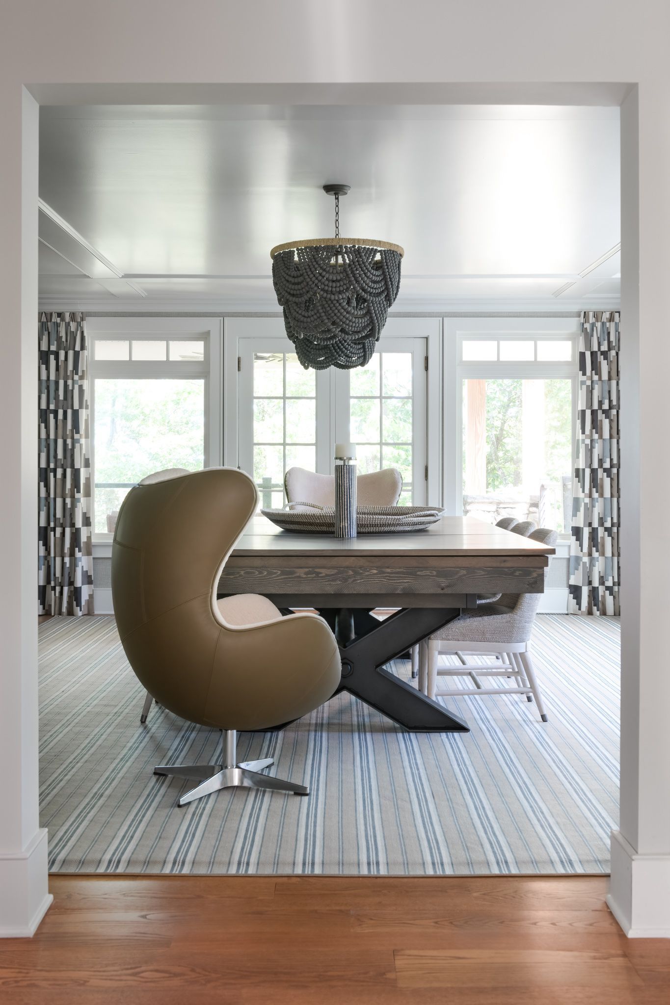A dining room with a table and chairs and a chandelier hanging from the ceiling.