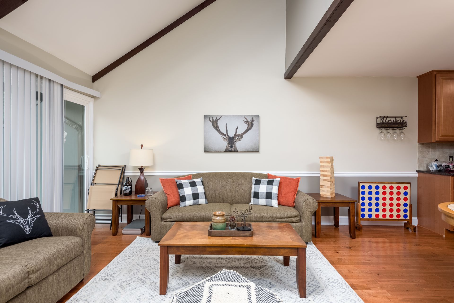 A living room with a couch , two chairs , a coffee table and a game.