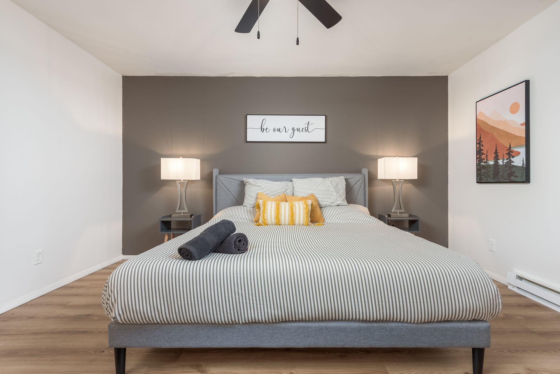 A bedroom with a large bed and a ceiling fan.