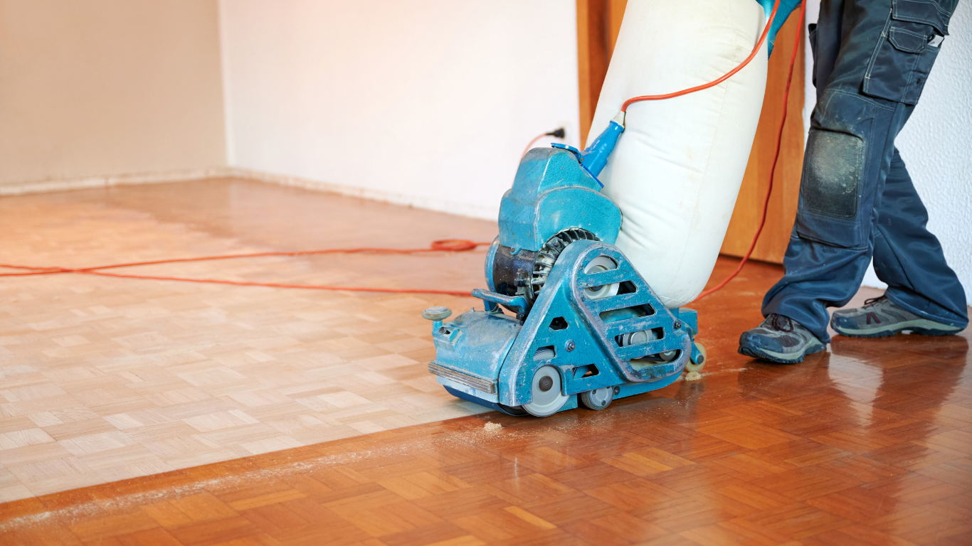 A living room with a blue couch , chairs , table and rug.
