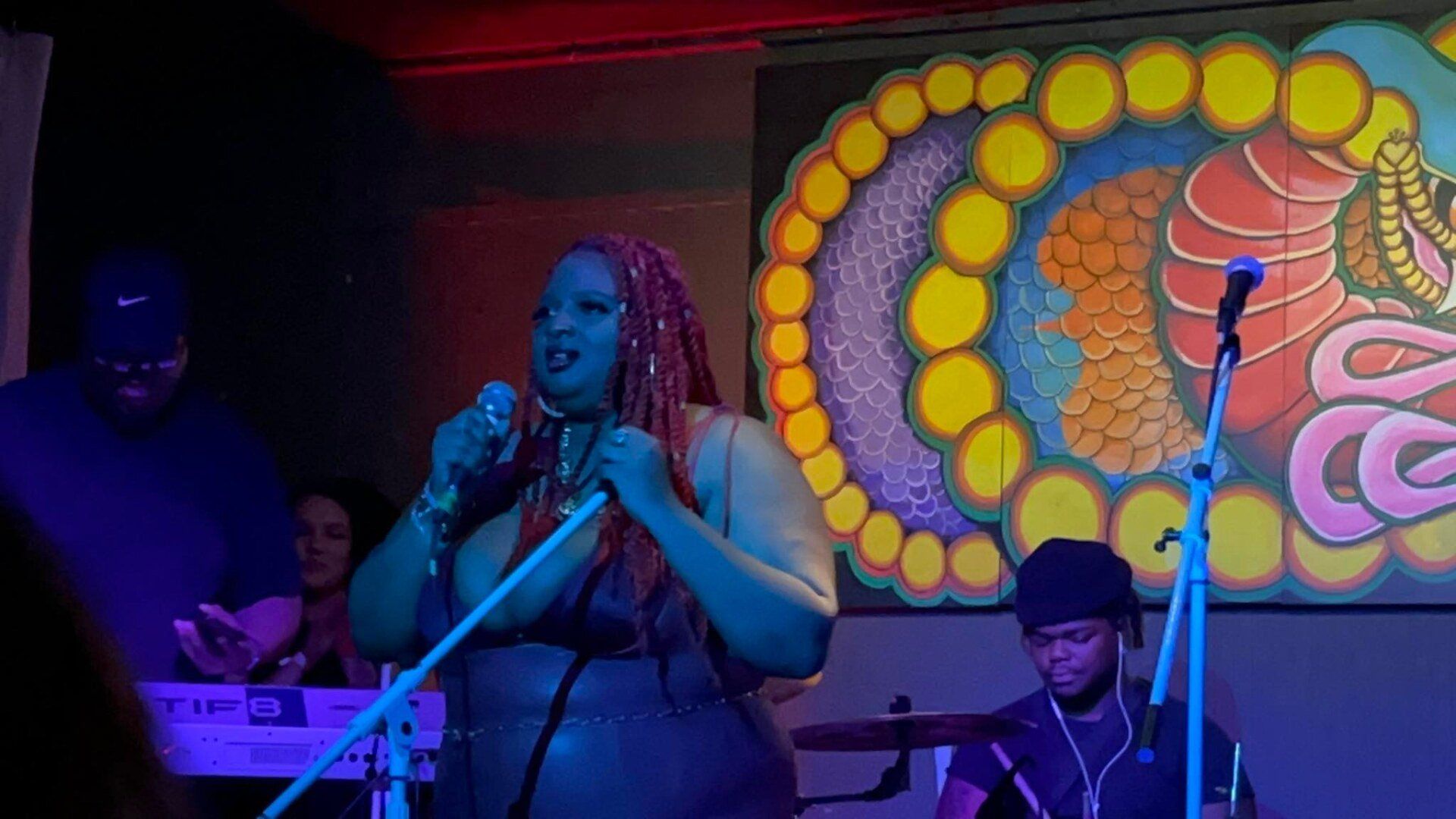 A woman is singing into a microphone on a stage.