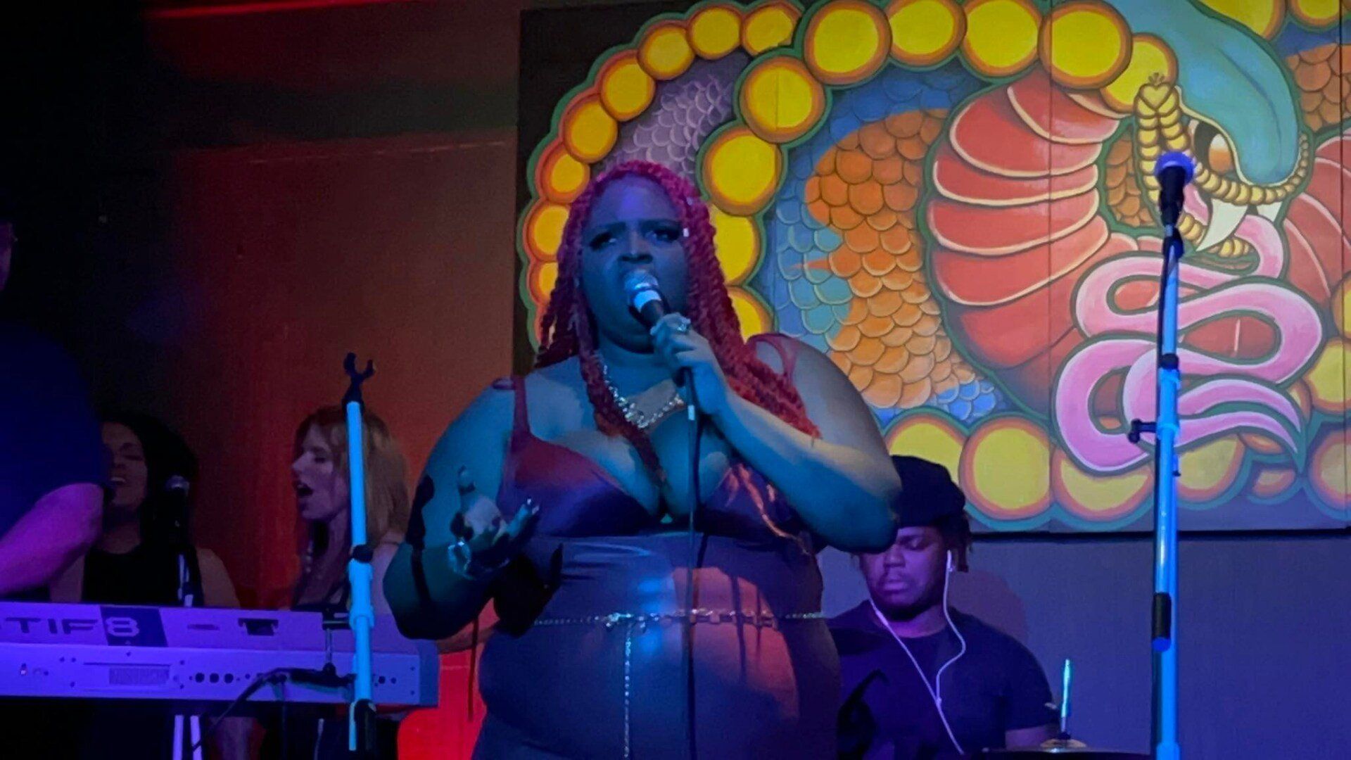 A woman is singing into a microphone on a stage.