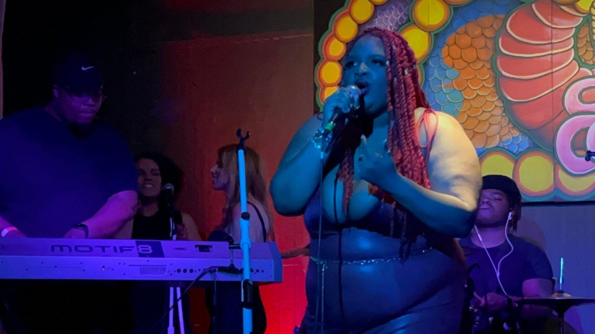 A woman is singing into a microphone on a stage.