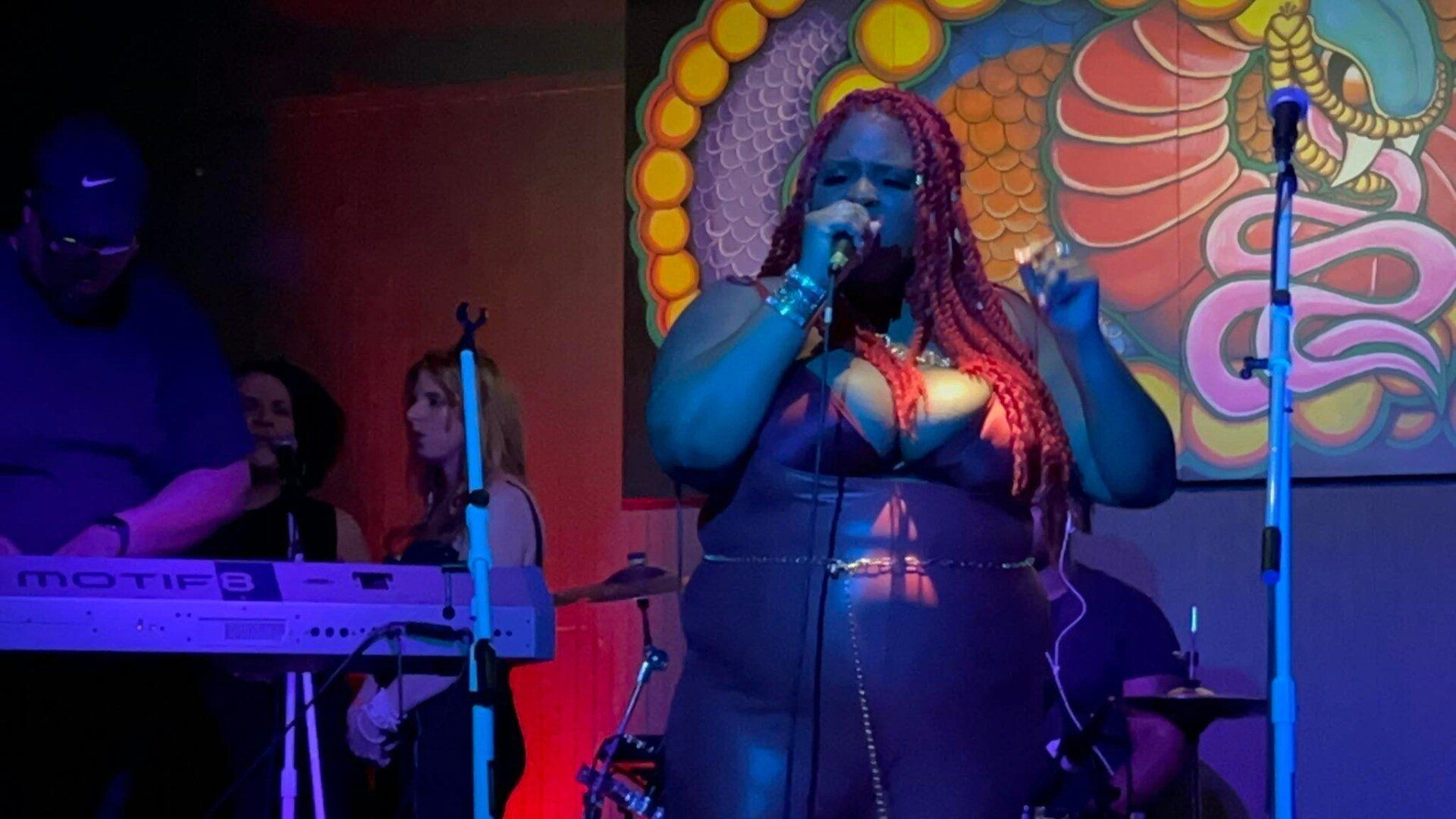 A woman is singing into a microphone on a stage.