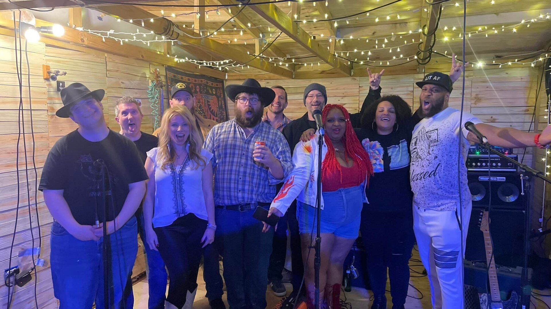 A group of people are standing in front of microphones in a room.