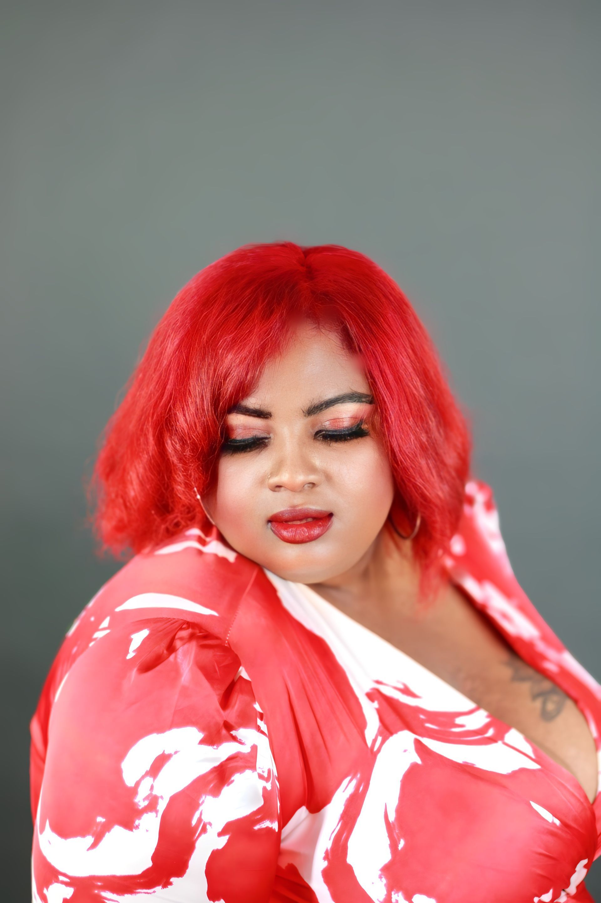 A woman with red hair is wearing a red and white dress.