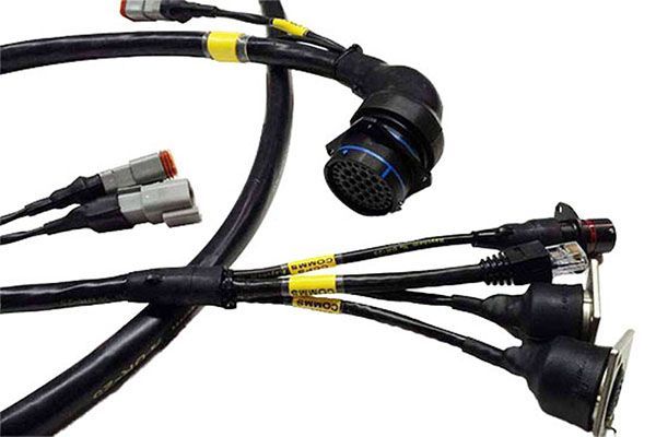 A black electrical wiring harness featuring a multi-pin circular connector, various sensor plugs, and yellow labels.