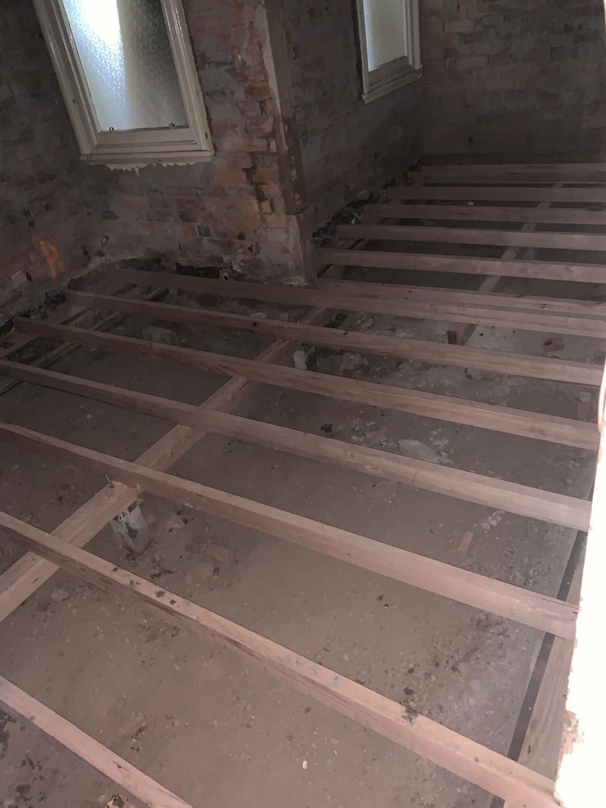 A room with a wooden floor and a brick wall.