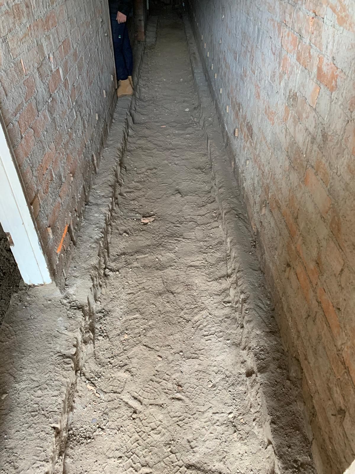 A person is standing in the middle of a narrow tunnel.